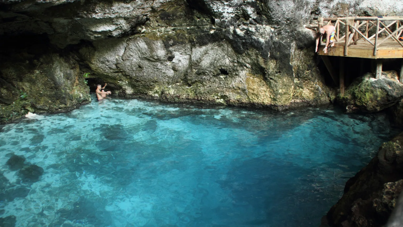 Foto real do Hoyo Azul em Punta Cana, com água azul e zona rochosa.