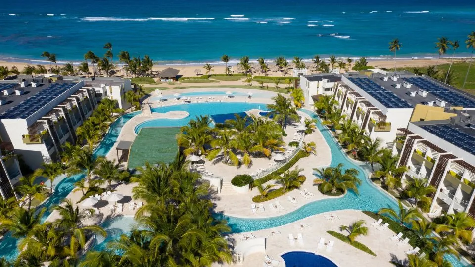 Vista real do Dreams Onyx Resort & Spa, com piscinas, edifícios e praia tropical.