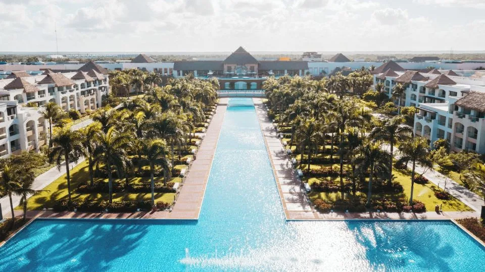 Vista real do Hard Rock Hotel & Casino Punta Cana, com piscina central e edifícios do resort.