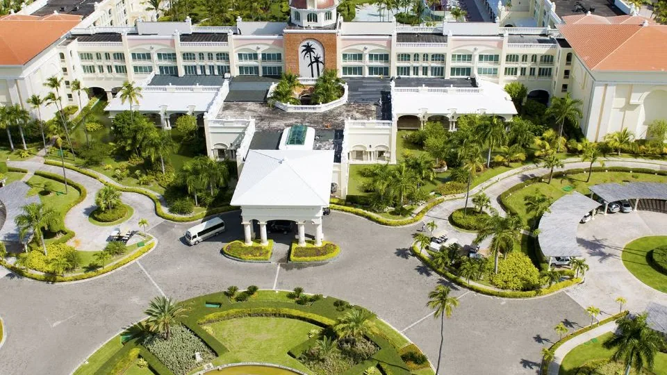 Vista real do Iberostar Selection Bávaro Suites, com entrada ajardinada e edifícios do resort.
